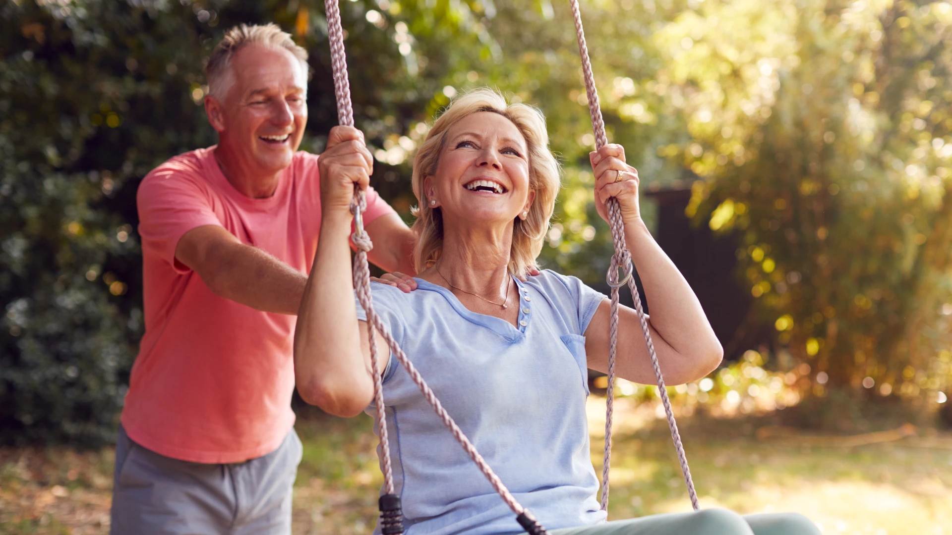 A man and woman swinging on a swing.