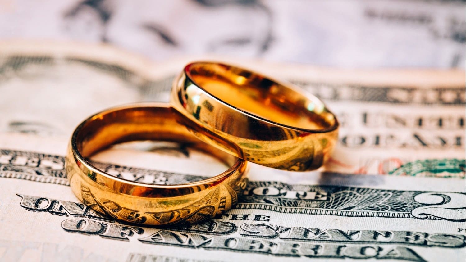 Wedding rings resting on cash