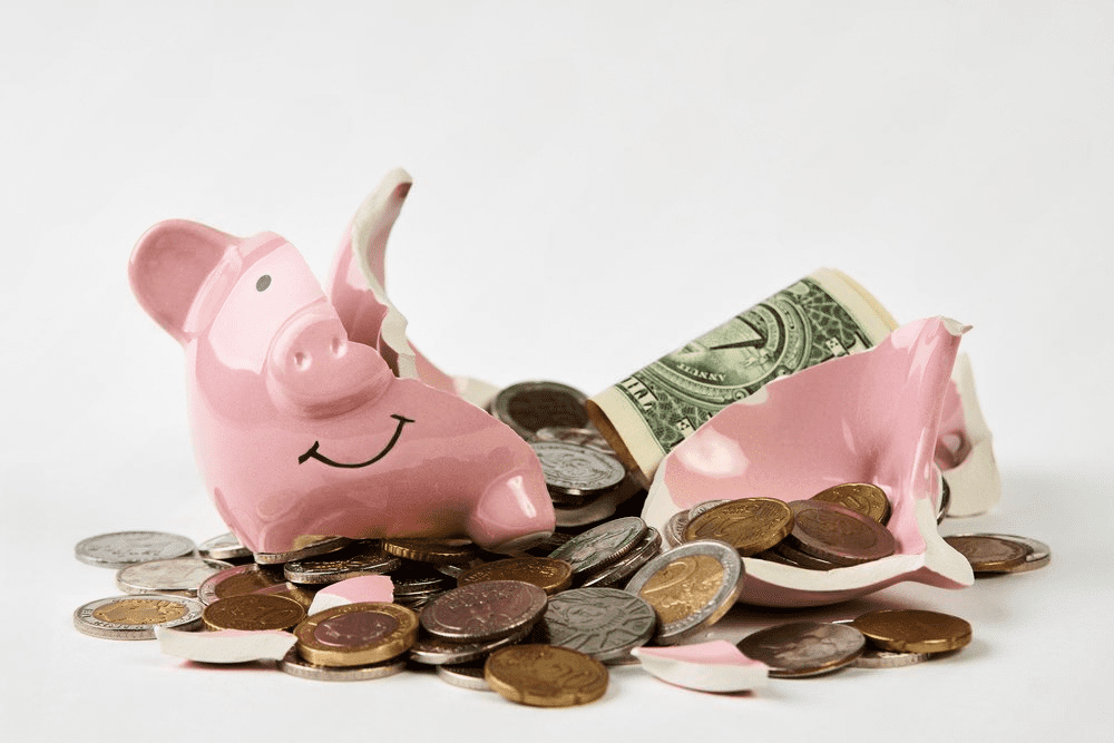 A couple of pink piggy banks sitting on top of some coins.