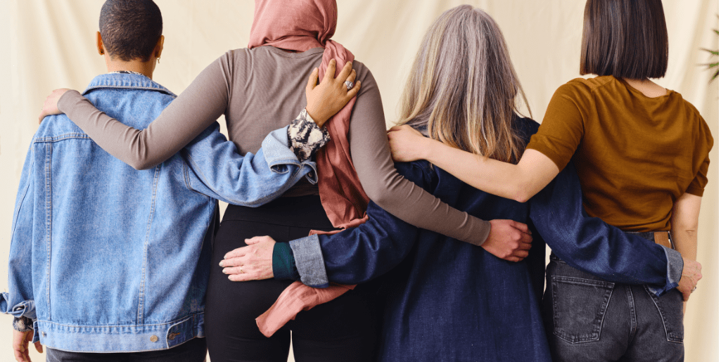 Three people are hugging each other in a circle.