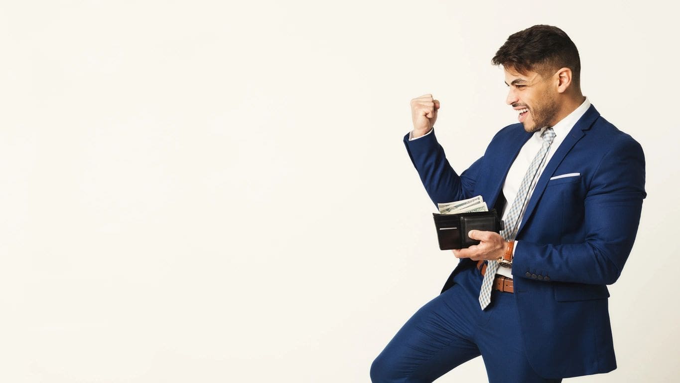 Excited businessman in blue suit holding wallet