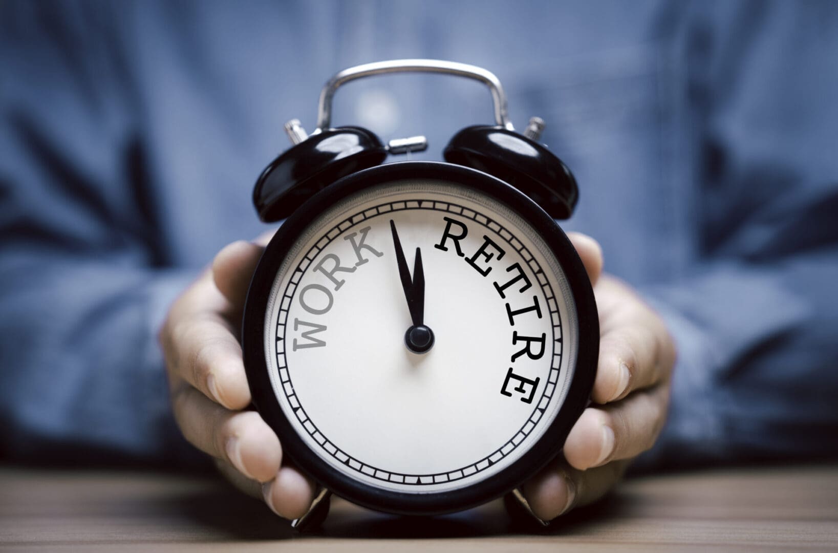 A person holding an alarm clock with the words " work and retire ".