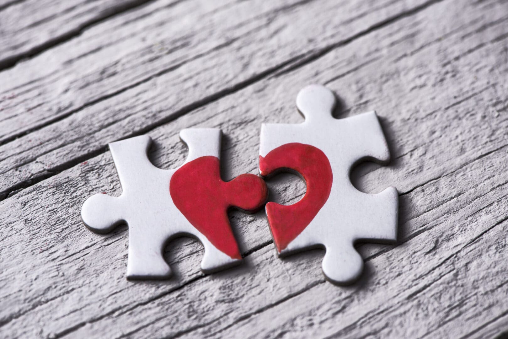 Two pieces of puzzle with a heart cut out